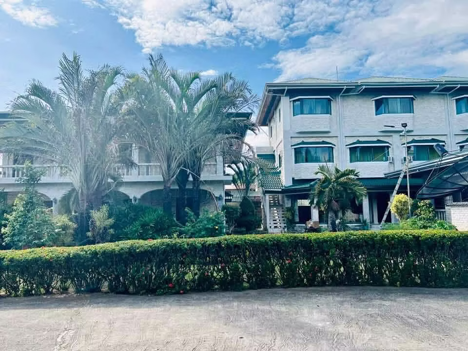 Villa Österreich Resort exterior with palm trees and green roofs